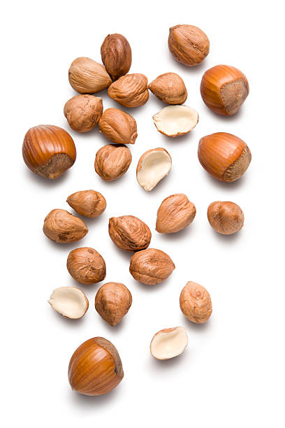 Several hazelnuts lying on a white surface stock photo