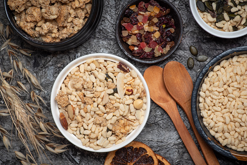 Several types of protein muesli with dried fruit on a black wooden background. Top view