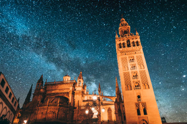 Seville at night Giralda tower under the Milky Way. Seville, Spain. seville cathedral stock pictures, royalty-free photos & images
