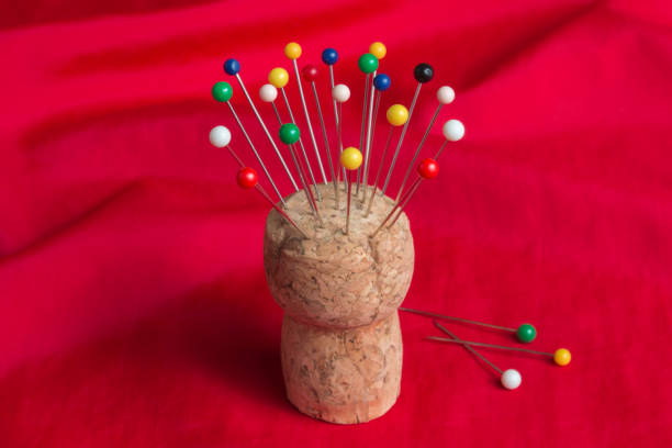 Sewing pins in cork pincushion on red fabric stock photo
