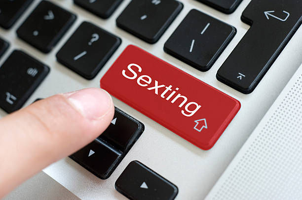 Sexting button on laptop stock photo