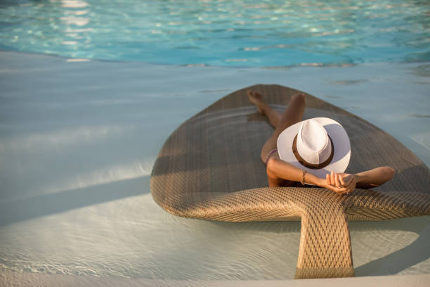 Sexy Woman relaxing at the luxury poolside. stock photo