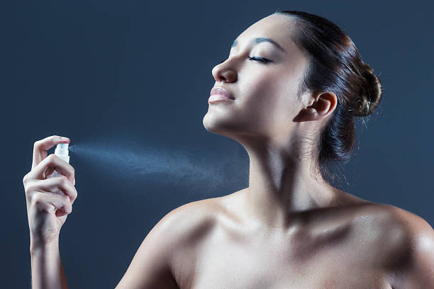 Sexy Young Hispanice Woman Spraying Self with Perfume stock photo