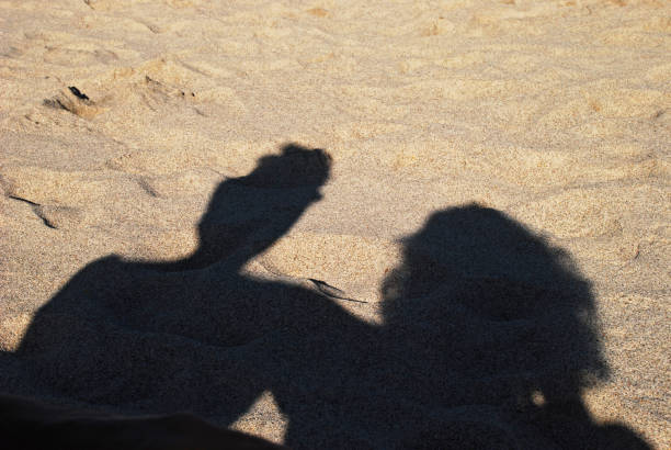 Shadows of a couple on sand stock photo