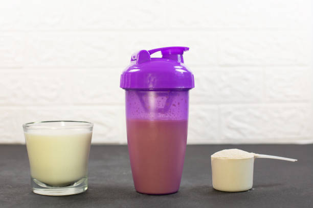 Shaker, Measuring scoop of protein powder and glass of milk stock photo