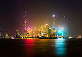 Shanghai Skyline at night with moon and fog in the air - long exposure on river Huangpu