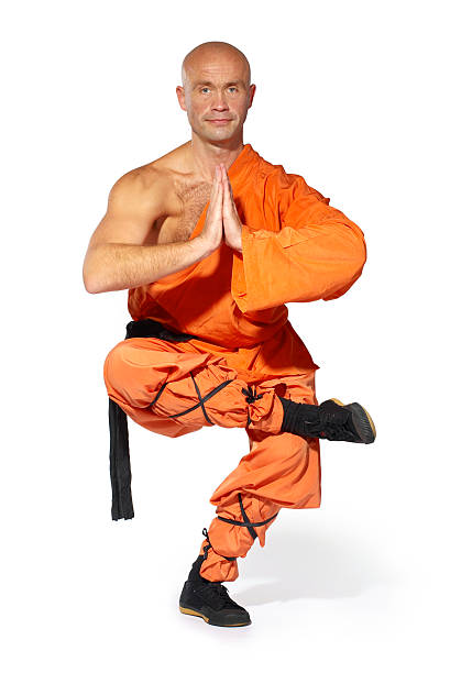 Shaolin warrior monk in a yoga pose isolated on white stock photo