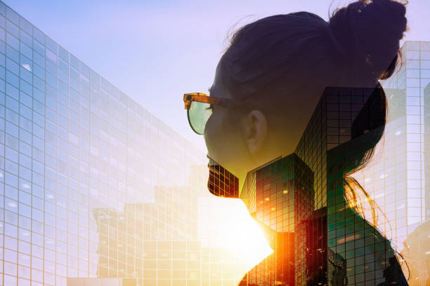 She is thinking of new strategies Business woman wearing sunglasses at sunset is looking at corporate office building. Double exposure photography contrasts photos stock pictures, royalty-free photos & images