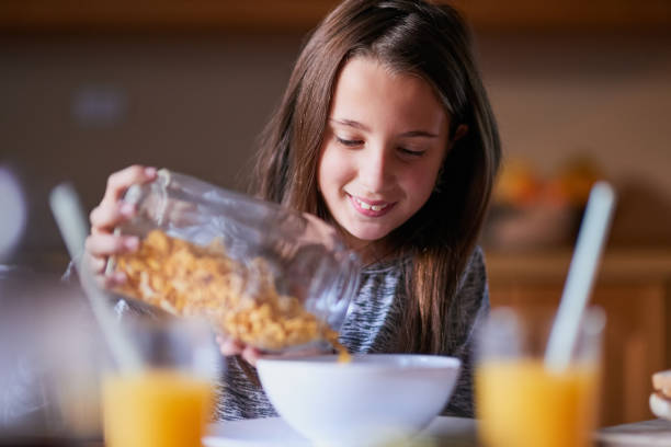 She loves cereal for breakfast, lunch and dinner Cropped shot of a young girl pouring cereal into a bowl by herself cereal stock pictures, royalty-free photos & images