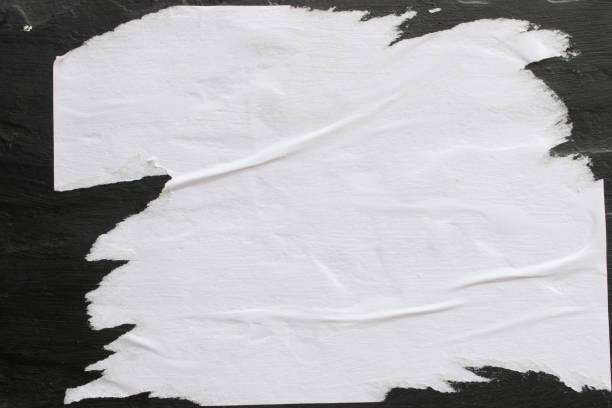 A sheet of white paper glued on a black wall. stock photo