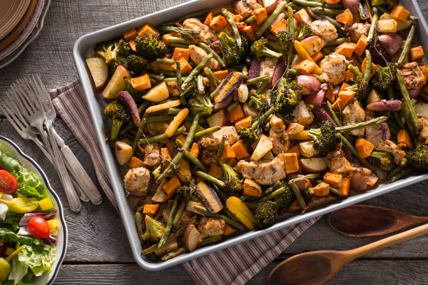 Sheet Pan Chicken Chicken Sheet Pan Dinner with Broccoli, Red Potatoes, Green Beans, Sweet Potatoes, Rainbow Carrots, Onion and Thyme. baking sheet stock pictures, royalty-free photos & images