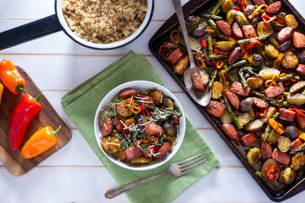 Sheet Pan Sausage Bowl of Healthy Sheet Pan Sausage, Asparagus, Potatoes, Brussels Sprouts and Sweet Mini Peppers over Quinoa. baking sheet stock pictures, royalty-free photos & images