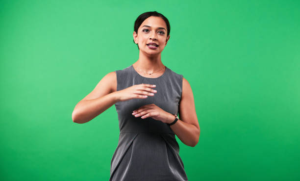She'll make sure you're well informed of the weather Cropped shot of an attractive young female weather forecaster reporting the weather against a green background sign language stock pictures, royalty-free photos & images