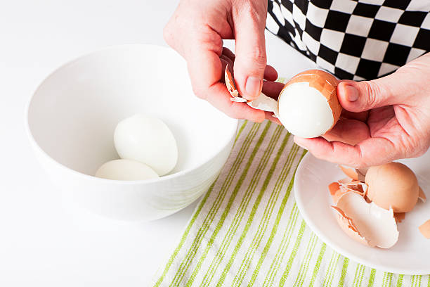 shelling boiled eggs stock photo