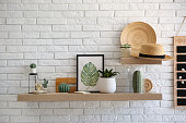 istock Shelves with decorative elements on white brick wall. Interior design 1353974021