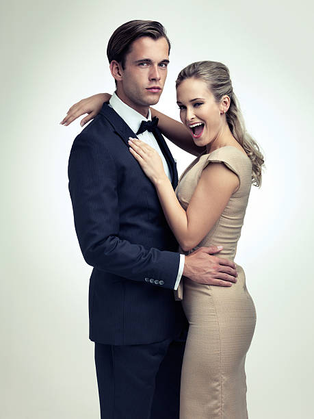 She's got herself a toy boy A studio portrait of a couple in stylish vintage evening wear cougar woman stock pictures, royalty-free photos & images