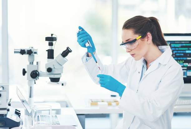 She's in concentration mode Cropped shot of a focused young female scientist wearing protective glasses while pouring a test sample into a vile inside of a laboratory physics photos stock pictures, royalty-free photos & images