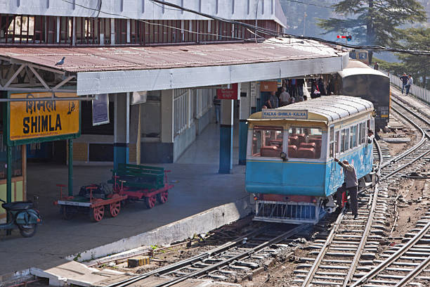 Shimla railway station below the Himalayan mountains, India Shimla, India - March 21, 2014: An unidentified driver mounts a train at the railway station at the end of the line linking the town with Kalka in the Himalayan foothills shimla stock pictures, royalty-free photos & images