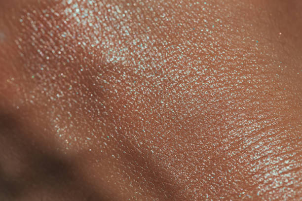 Shimmering cosmetic product blended on human skin. Macro view of creme highlight swatch. human skin close up stock pictures, royalty-free photos & images