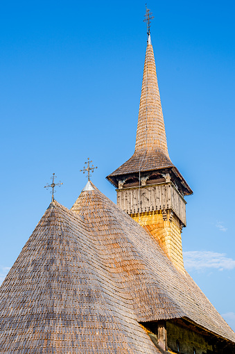 Barsana, Maramures county, Transylvania, Romania - August 2021: Shingle roof of old traditional wooden church of old Barsana Monastery, a UNESCO world heritage site. Wooden roof with three towers and crosses