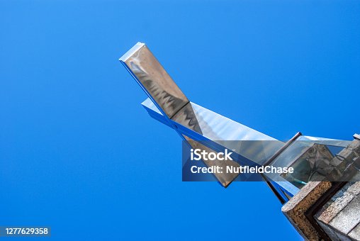 istock A shiny and reflective cross viewed against blue sky 1277629358