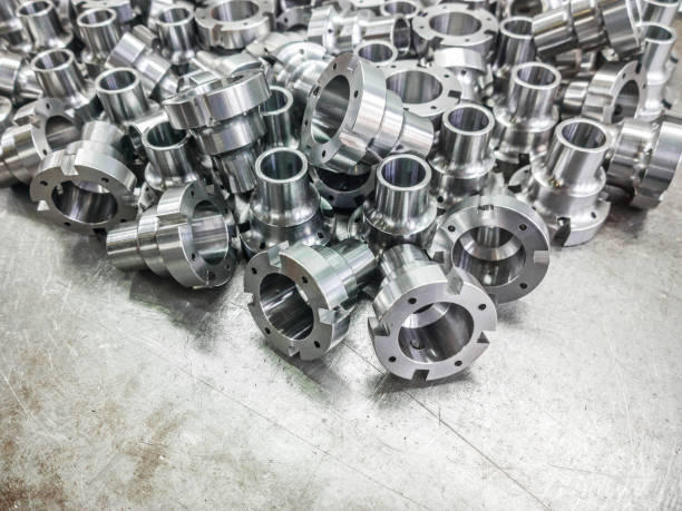 Shiny steel parts after cnc turning, drilling and machining on steel surface with selective focus. Shiny steel parts after cnc turning, drilling and machining on steel surface selective focus composition background. cnc machine stock pictures, royalty-free photos & images