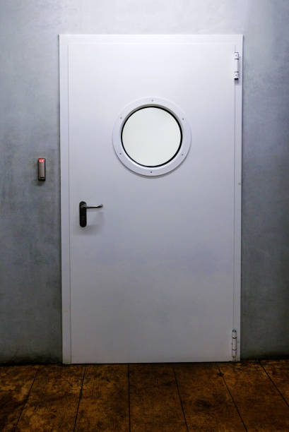 Ship door with porthole and industrial environment. stock photo