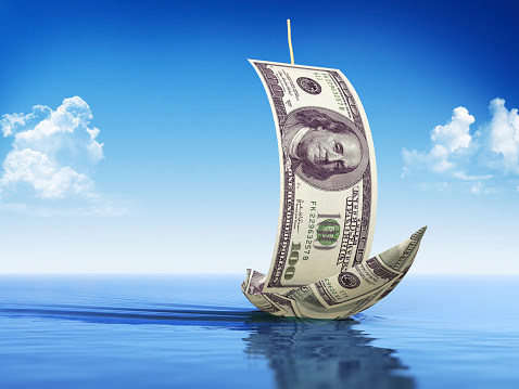 ✓ Imagen de American 1hundred dólar barco de papel sobre el paisaje  cubierto de dinero sobre el cielo Fotografía de Stock