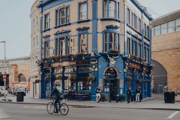 shipwrights wapens pub gelegen in london bridge, londen, uk, man fietsen verleden, bewegingsonscherpte. - south bank london stockfoto's en -beelden