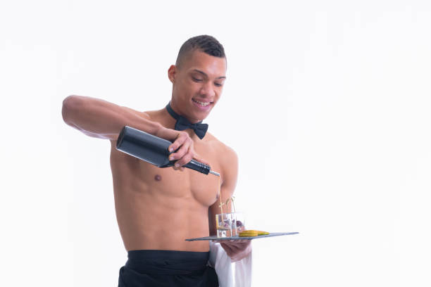camarero joven sin camisa llenando fotos de vidrio con licor - topless waiter fotografías e imágenes de stock