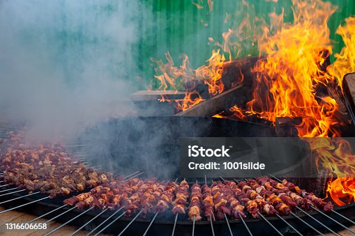 istock Shish kebabs on a very large barbecue ready to be cooked 1316606658