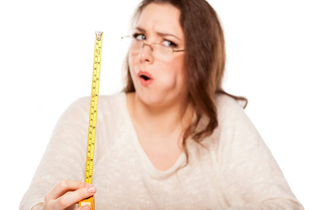 shocked by the size young woman is shocked by the size shown on the measuring tape human mouth gag adhesive tape women stock pictures, royalty-free photos & images