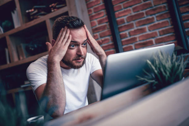 Shocked Freelancer in Disbelief Working at his Favorite Coffee Place Shocked Freelancer in Disbelief Working at his Favorite Coffee Place shock stock pictures, royalty-free photos & images