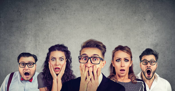 Shocked man in glasses and his scared friends stock photo