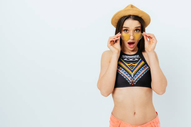 Shocked young woman wearing summer beach outfit with straw hat stock photo