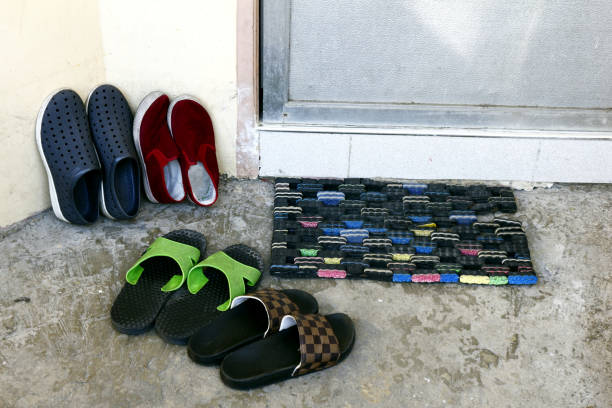 Shoes and slippers on the doorway of a house stock photo