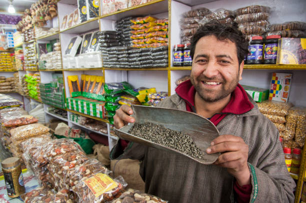 A shop keeper in Kashmir, India shows loose green tea known as Kahwah stock photo