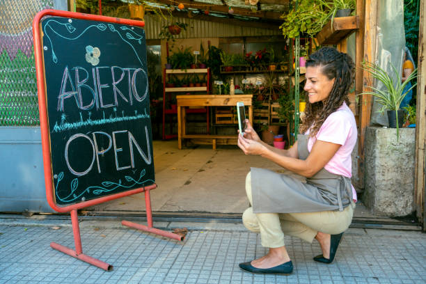 Shop owner drawing open on blackboard sign stock photo
