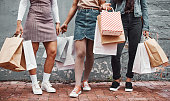 Cropped shot of an unrecognizable group of sisters standing together with their shopping bags during a day in the city