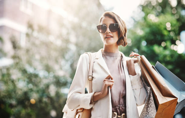 Shopping always makes her happy Shot of a gorgeous and elegant young woman out on a shopping spree affluent lifestyles stock pictures, royalty-free photos & images