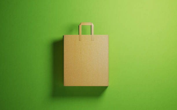shopping bag tillverkad av återvunnet papper på grön bakgrund - brown paper bag bildbanksfoton och bilder