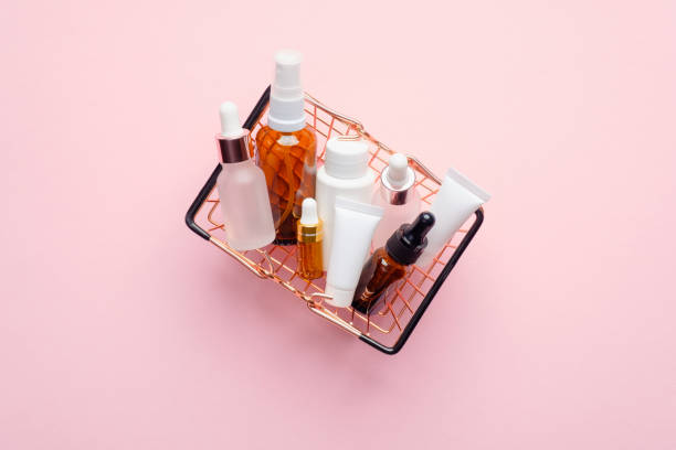 Shopping basket full of cosmetic bottles and packaging on pink background, view from above. Cosmetics sale or discount concept.  products stock pictures, royalty-free photos & images
