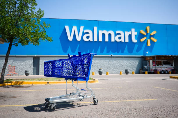 Shopping cart on a parking lot in front of main entrance to Walmart supermarket with no people stock photo