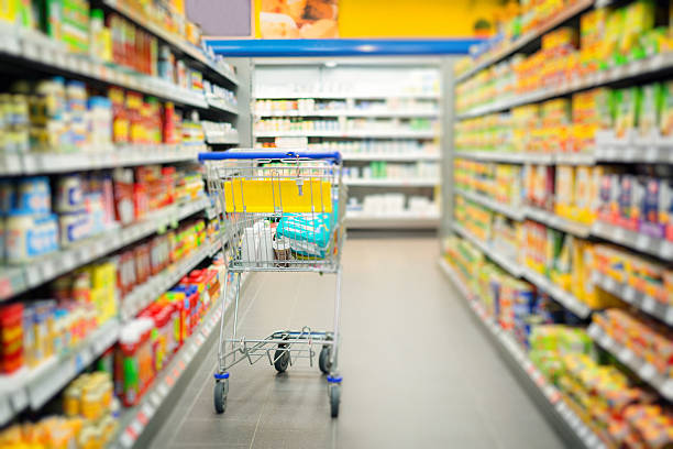 shopping cart standing in a supermarket's aisle stock photo