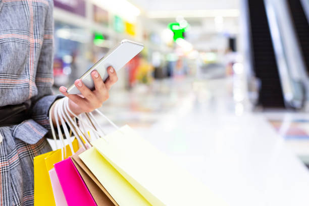 shopping koncept. kvinna som använder smartphone i big mall - shopping center bildbanksfoton och bilder