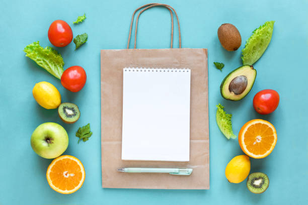Shopping healthy food Healthy food background. Healthy food and paper bag vegetables and fruits on blue, copy space. Shopping list food supermarket concept. shopping list stock pictures, royalty-free photos & images