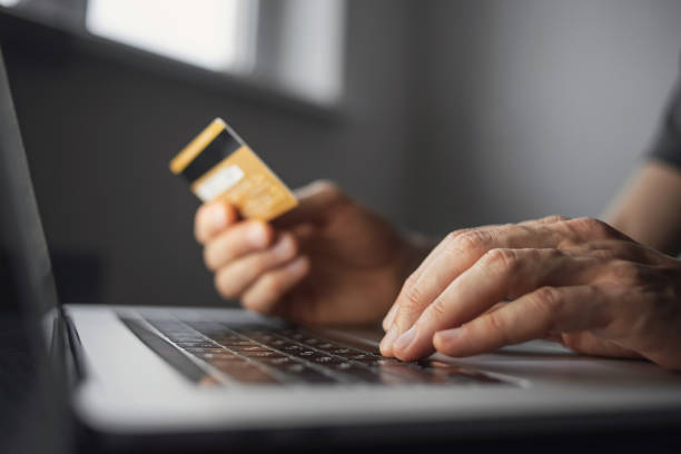 온라인 쇼핑. 집에서 신용 카드와 노트북을 사용 하는 젊은 남자 - 전자 상거래 뉴스 사진 이미지