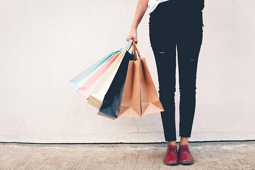 woman wear black jeans holding shopping bag on the ground