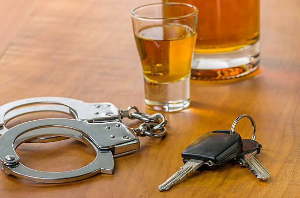 Shot glass with car keys and handcuffs Shot glass with car keys and handcuffs bar drink establishment photos stock pictures, royalty-free photos & images