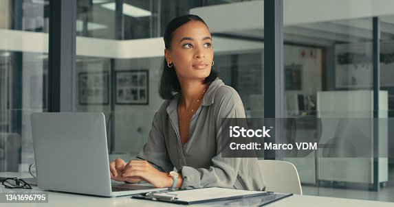 istock Shot of a beautiful young woman lost in thought while using her laptop in a modern office 1341696795